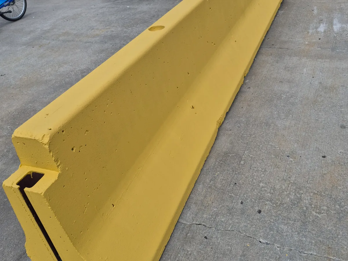Freshly painted yellow concrete wheel stop on a concrete parking deck